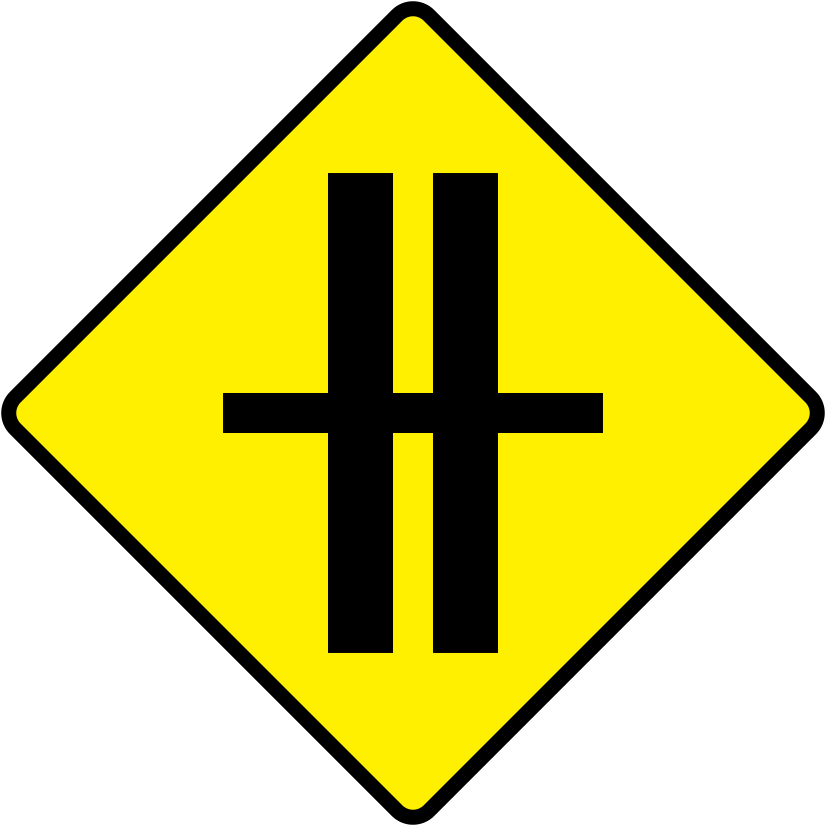 A triangular warning traffic sign in Ireland depicting crossroads on dual c'way. Memorize for DTT.